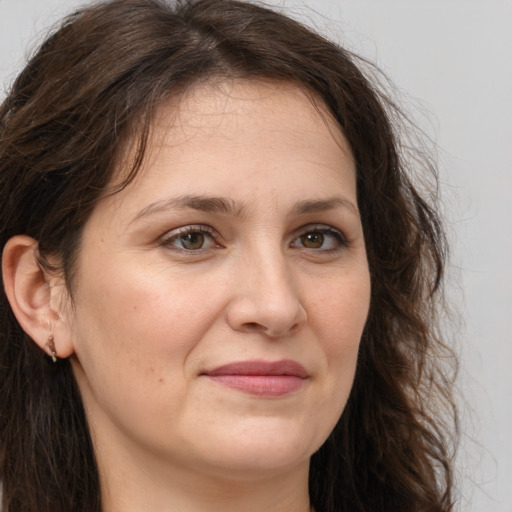 Joyful white adult female with long  brown hair and brown eyes