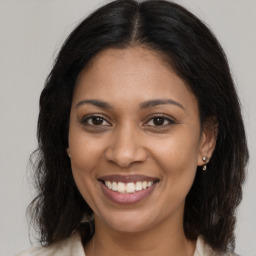 Joyful black young-adult female with medium  brown hair and brown eyes