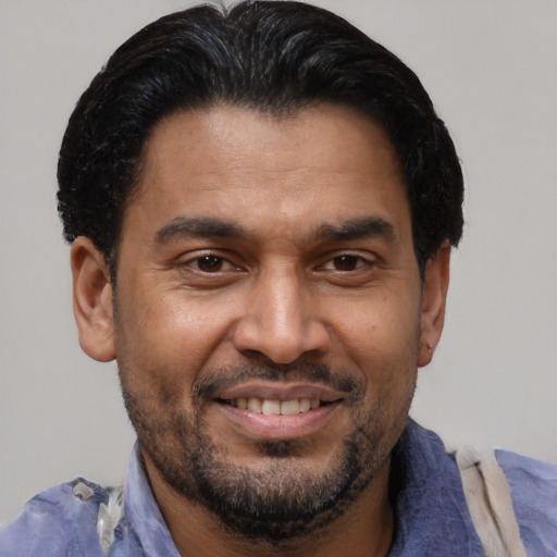 Joyful latino adult male with short  brown hair and brown eyes