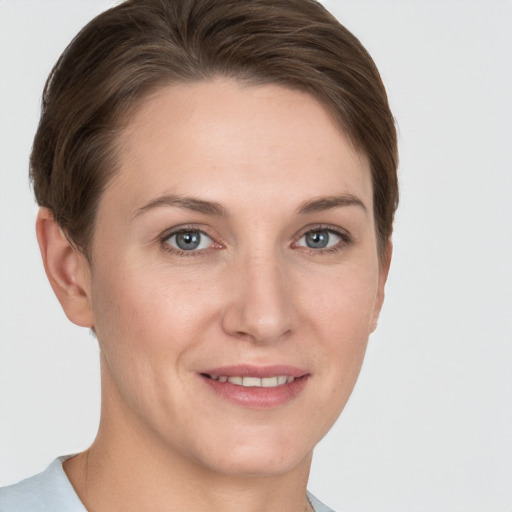 Joyful white young-adult female with short  brown hair and grey eyes