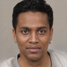 Joyful black young-adult male with short  black hair and brown eyes