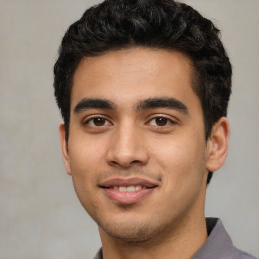 Joyful white young-adult male with short  black hair and brown eyes