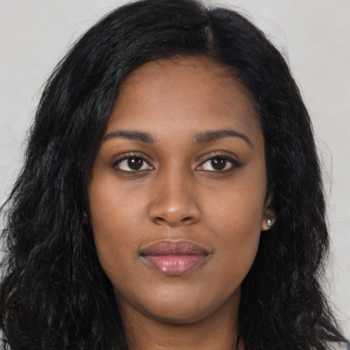 Joyful black young-adult female with long  black hair and brown eyes