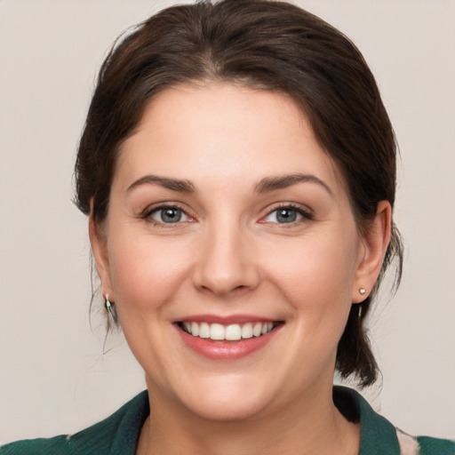 Joyful white young-adult female with medium  brown hair and grey eyes