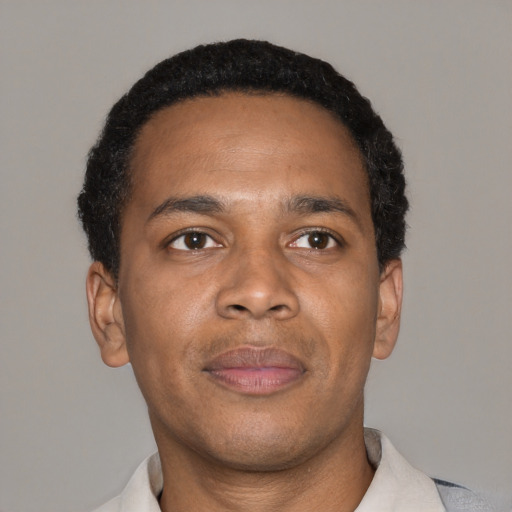 Joyful black young-adult male with short  brown hair and brown eyes