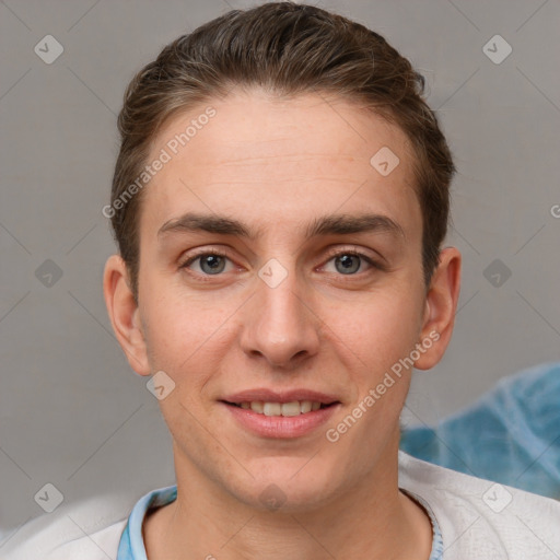 Joyful white young-adult male with short  brown hair and grey eyes