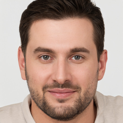 Joyful white young-adult male with short  brown hair and brown eyes