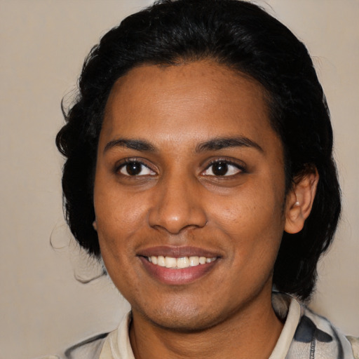 Joyful black young-adult female with medium  black hair and brown eyes