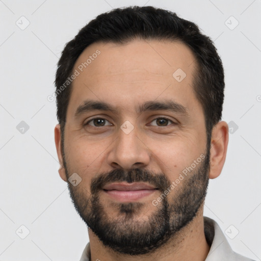 Joyful white young-adult male with short  black hair and brown eyes