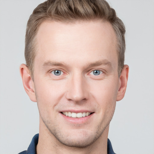 Joyful white young-adult male with short  brown hair and blue eyes