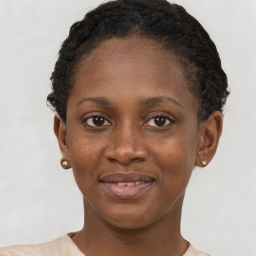 Joyful black young-adult female with short  brown hair and brown eyes