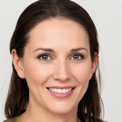 Joyful white young-adult female with long  brown hair and grey eyes