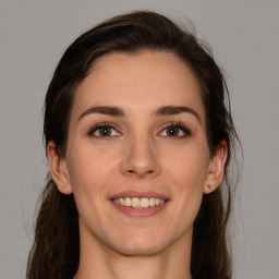 Joyful white young-adult female with long  brown hair and brown eyes