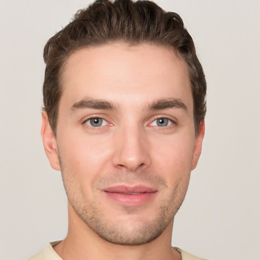 Joyful white young-adult male with short  brown hair and grey eyes