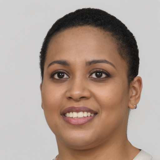 Joyful black young-adult female with short  black hair and brown eyes