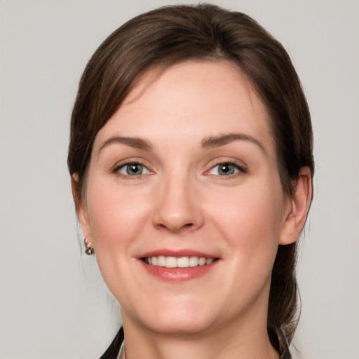 Joyful white young-adult female with medium  brown hair and grey eyes