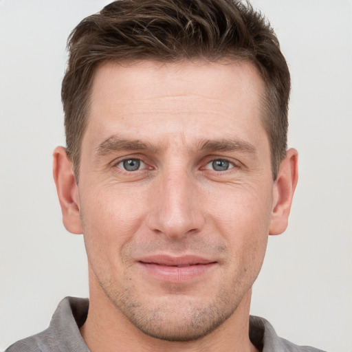 Joyful white adult male with short  brown hair and grey eyes