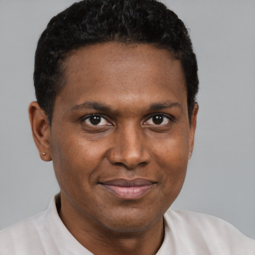 Joyful black young-adult male with short  brown hair and brown eyes
