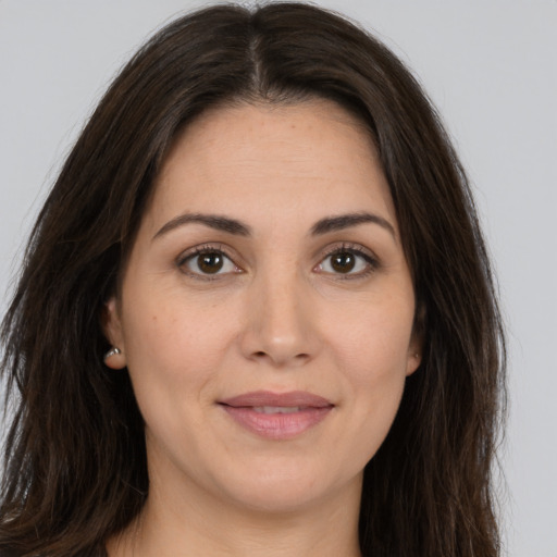 Joyful white young-adult female with long  brown hair and brown eyes