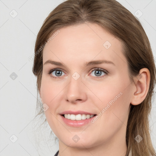 Joyful white young-adult female with long  brown hair and grey eyes