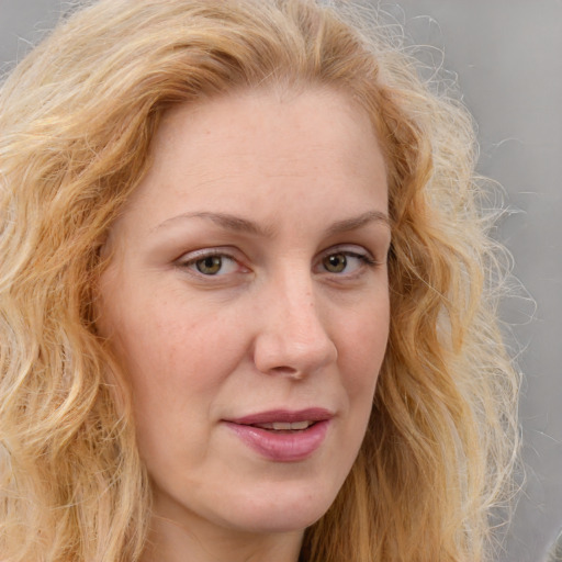 Joyful white young-adult female with long  blond hair and blue eyes