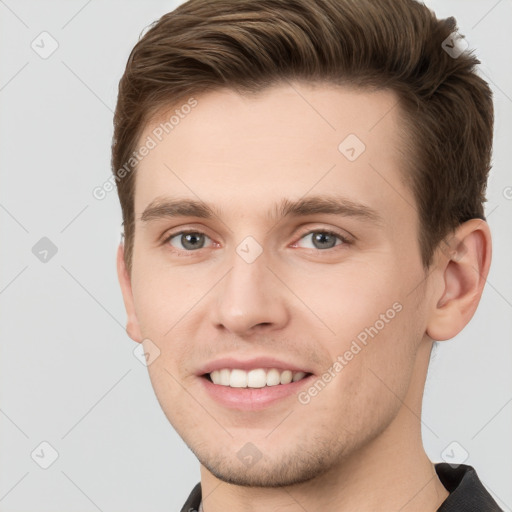 Joyful white young-adult male with short  brown hair and grey eyes