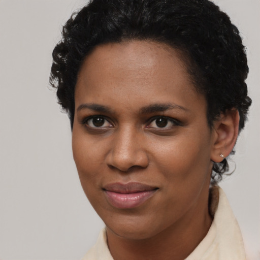 Joyful black young-adult female with short  black hair and brown eyes