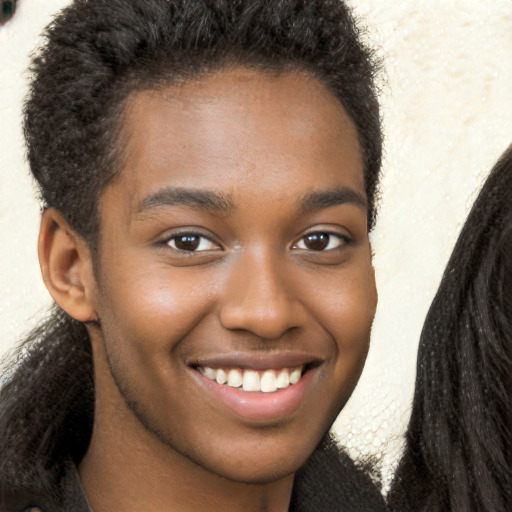 Joyful black young-adult male with long  brown hair and brown eyes