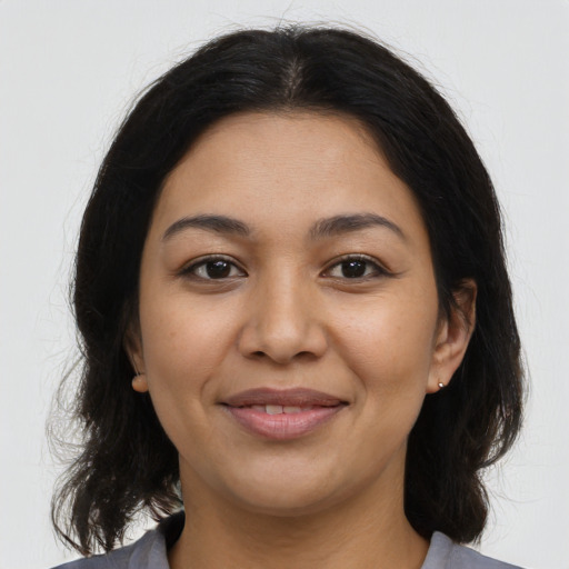 Joyful latino young-adult female with medium  brown hair and brown eyes