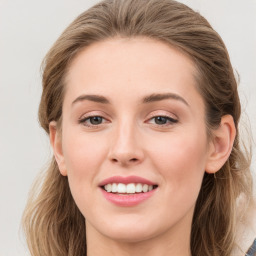 Joyful white young-adult female with long  brown hair and blue eyes