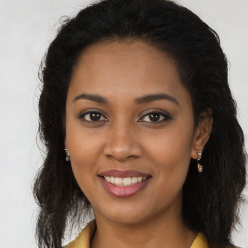 Joyful black young-adult female with long  brown hair and brown eyes