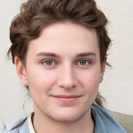 Joyful white young-adult male with short  brown hair and blue eyes