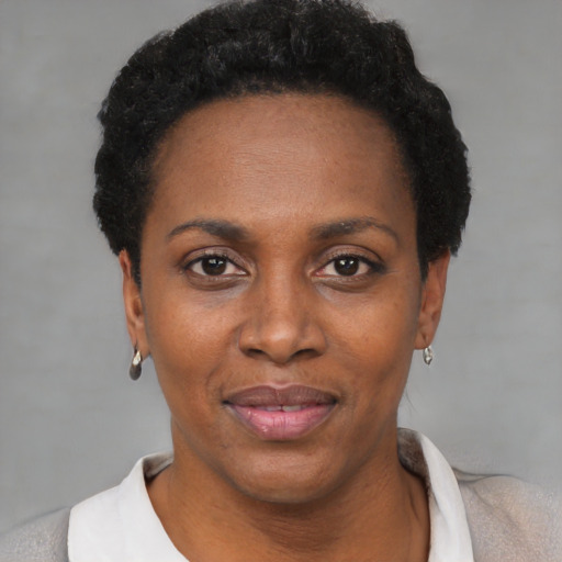 Joyful black adult female with short  black hair and brown eyes