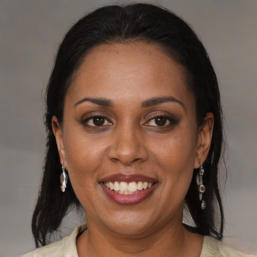 Joyful black adult female with medium  brown hair and brown eyes