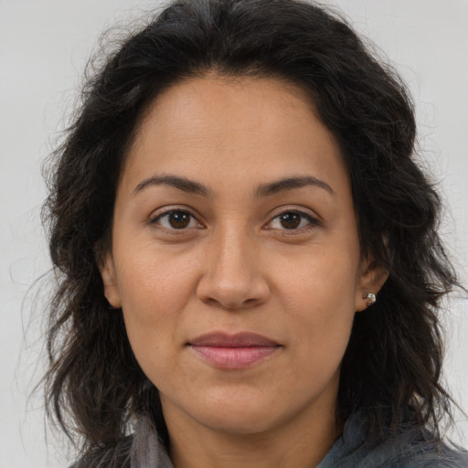 Joyful latino adult female with long  brown hair and brown eyes