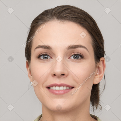 Joyful white young-adult female with medium  brown hair and grey eyes