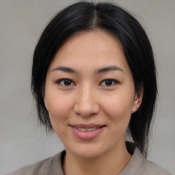 Joyful asian young-adult female with medium  black hair and brown eyes