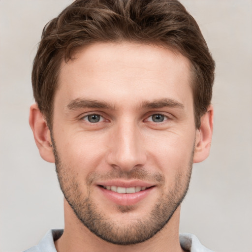 Joyful white young-adult male with short  brown hair and grey eyes