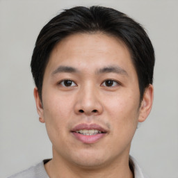 Joyful asian young-adult male with short  brown hair and brown eyes