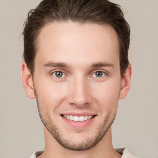 Joyful white young-adult male with short  brown hair and grey eyes