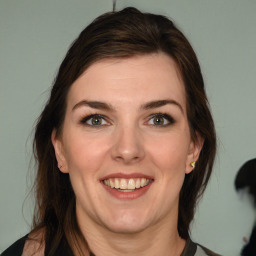 Joyful white young-adult female with medium  brown hair and green eyes