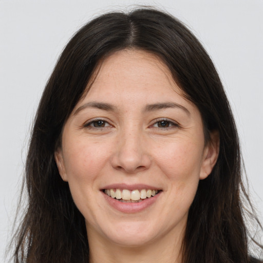 Joyful white adult female with long  brown hair and brown eyes