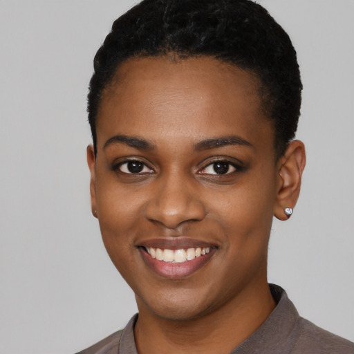 Joyful black young-adult female with short  black hair and brown eyes