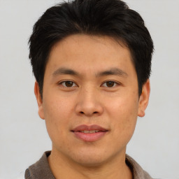 Joyful asian young-adult male with short  brown hair and brown eyes