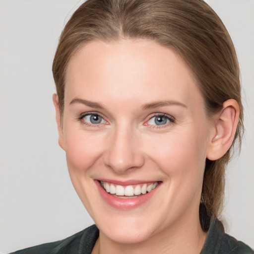 Joyful white young-adult female with medium  brown hair and blue eyes