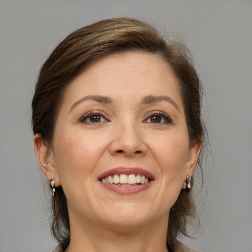 Joyful white adult female with medium  brown hair and grey eyes