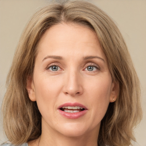 Joyful white adult female with medium  brown hair and green eyes