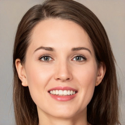 Joyful white young-adult female with long  brown hair and grey eyes