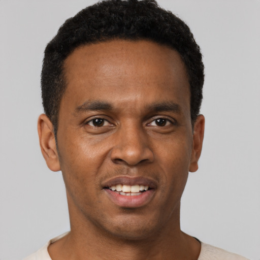 Joyful black young-adult male with short  black hair and brown eyes