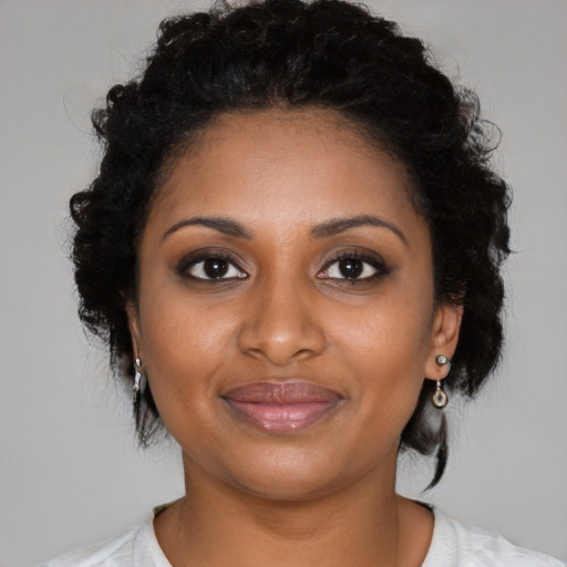 Joyful black young-adult female with medium  black hair and brown eyes